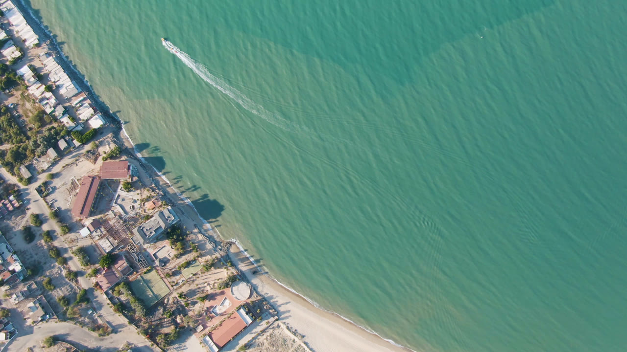 Aerial view of San Felipe, Mexico with green-blue water, a pale beach, clustered shoreline buildings, visible roads, and no visible people.