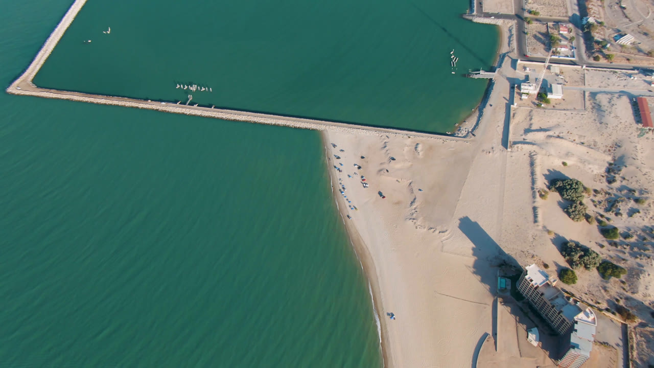 Drone view of San Felipe beach, pier house, and rectangular harbor edge.