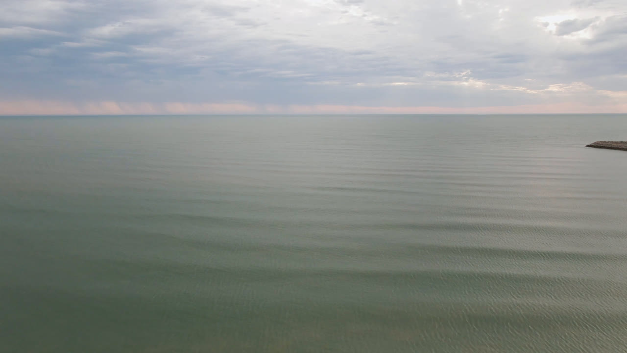At 0:00 in San Felipe, B.C., Mexico, green-gray water stretches to a cloudy horizon with no visible people.