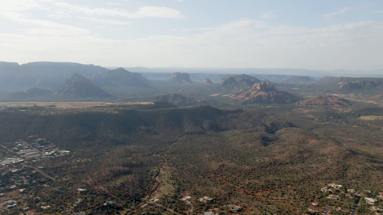 Aerial desert panorama with mesas, valley floor, and town edge
