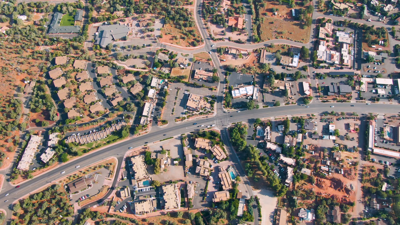 Overhead view of Sedona roads, buildings, trees, and red ground.