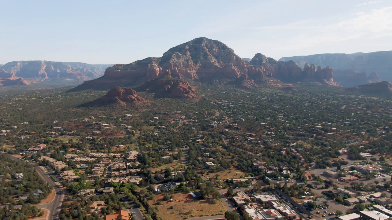 Third frame shows Sedona from above with more open terrain at left, residential and commercial-looking buildings below, layered red rocks beyond, and no visible people.