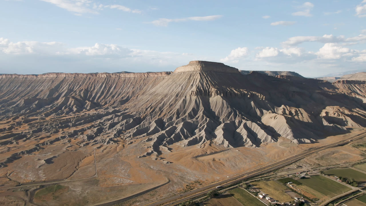 Aerial mesa landscape with desert ridges and fields below