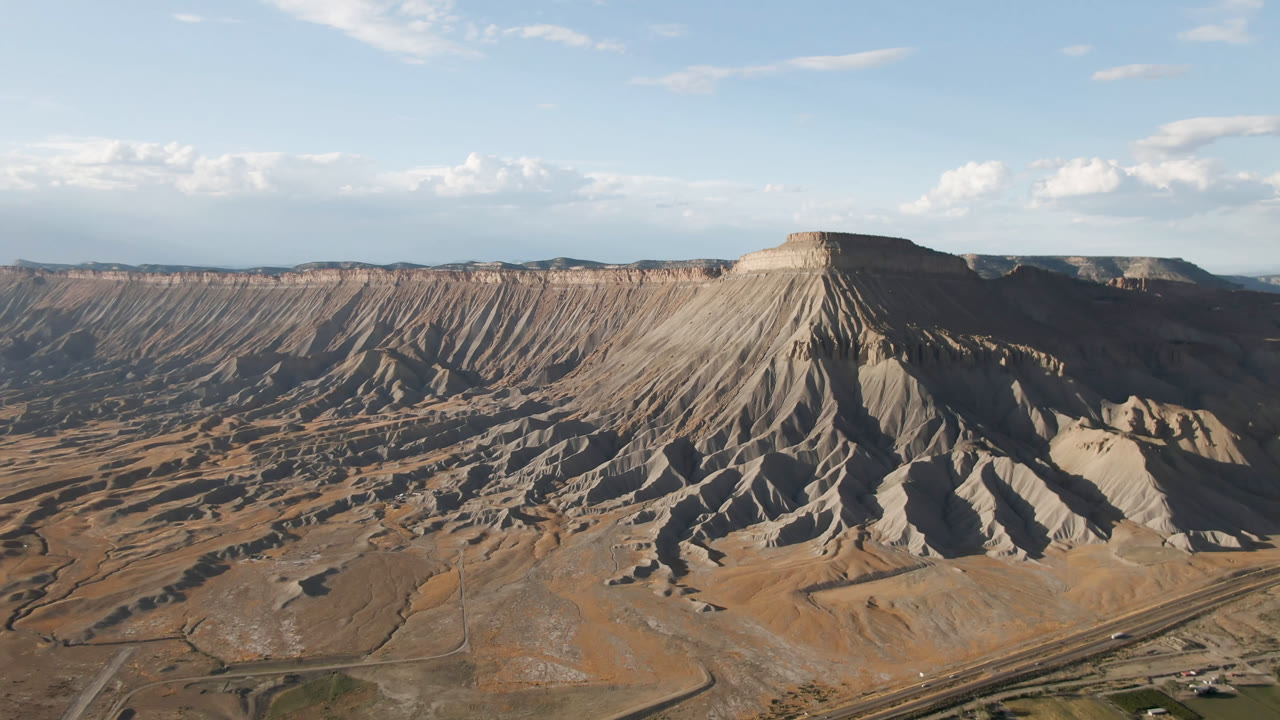 Aerial landscape with mesa slope and open sky.