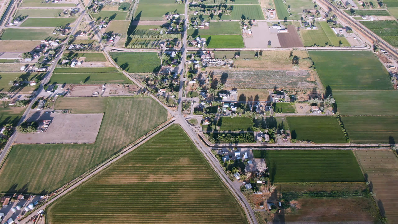 Aerial view of farmland, roads, houses, and trees.