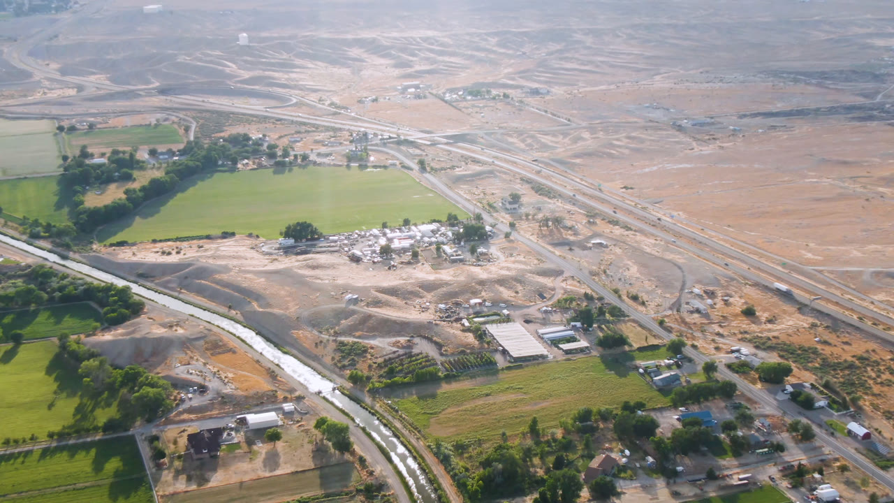 Aerial view of fields and a road network crossing dry open land.