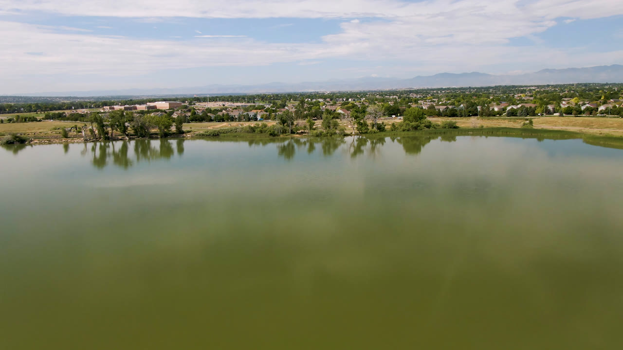 Second frame shows the Broomfield lake surface taking most of the view, with shoreline trees, low distant buildings, layered clouds, and no visible people.