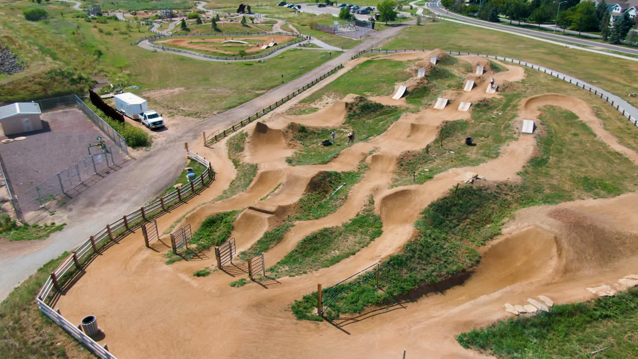 Third frame shows the Broomfield dirt bike park from above with the large berm in the lower right, looping paths through grass, roads at the top, and no visible people.