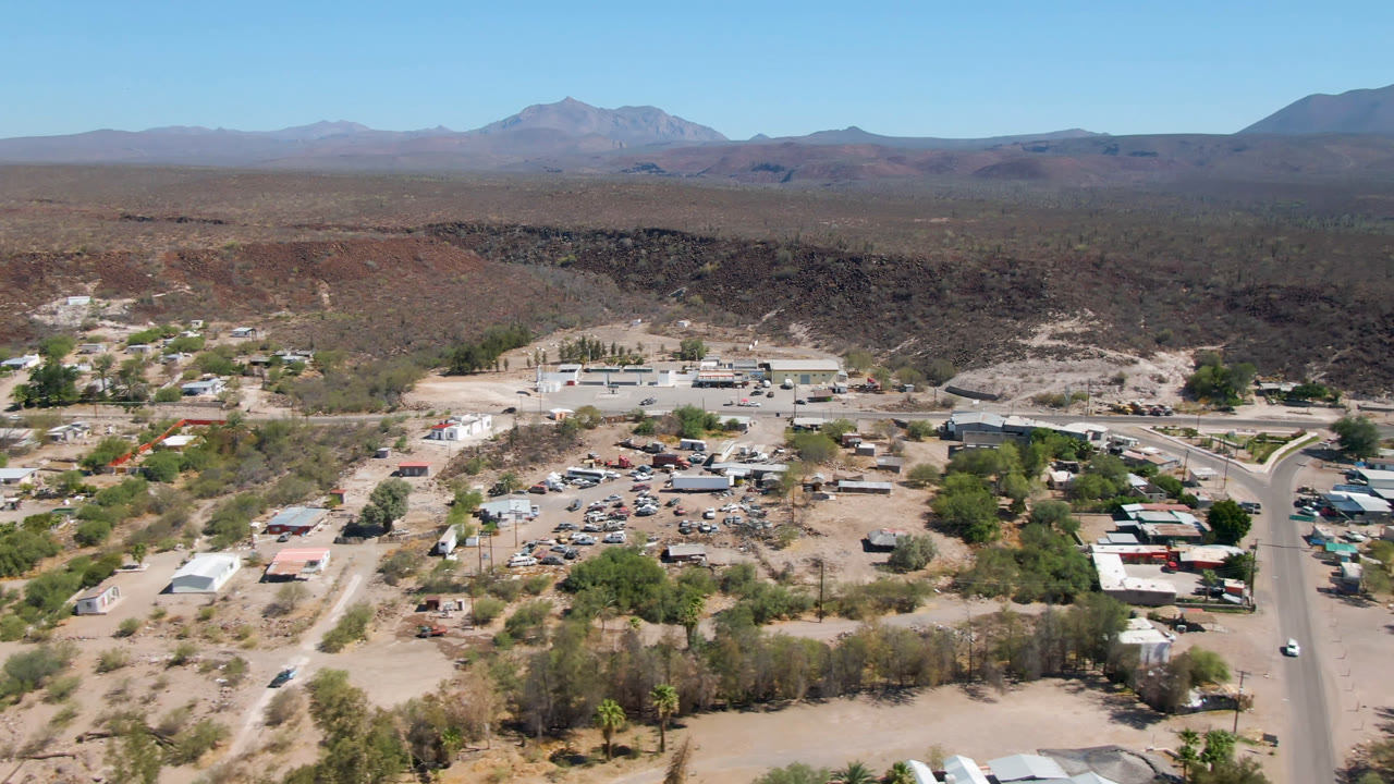 Aerial view of a desert town beside a road with mountains in the distance