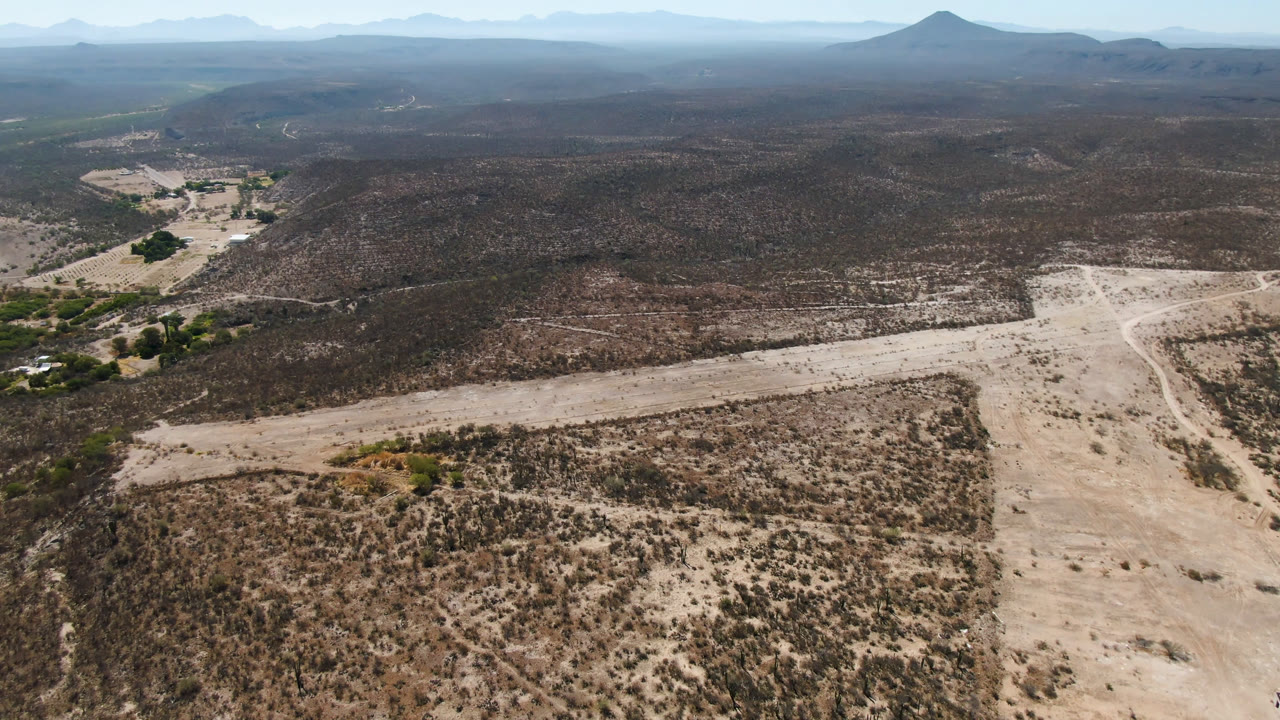 Aerial view of pale dirt roads crossing scrubby desert hills