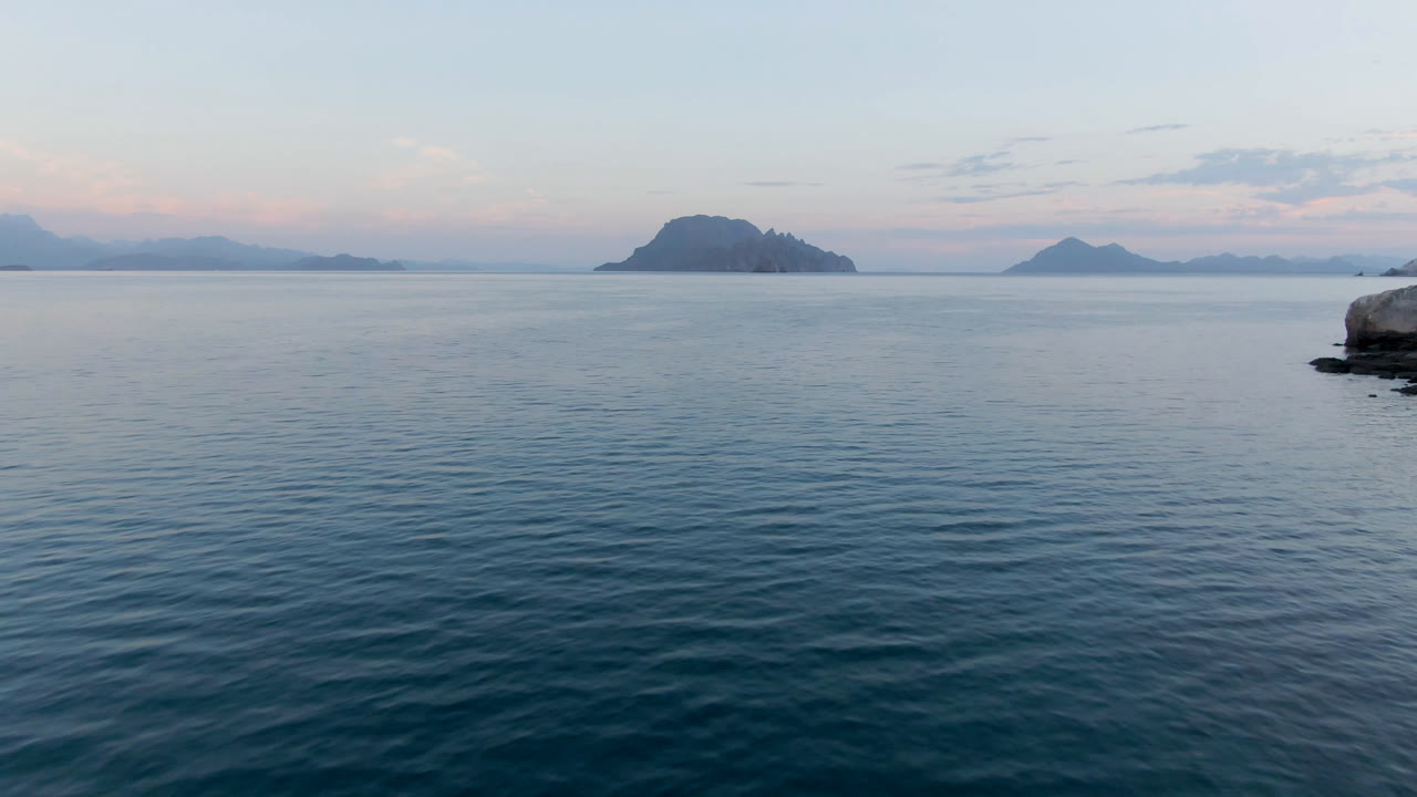 Opening frame from Danzante Bay Loreto showing blue ocean ripples, distant island silhouettes, pale cloud bands, and no visible people.