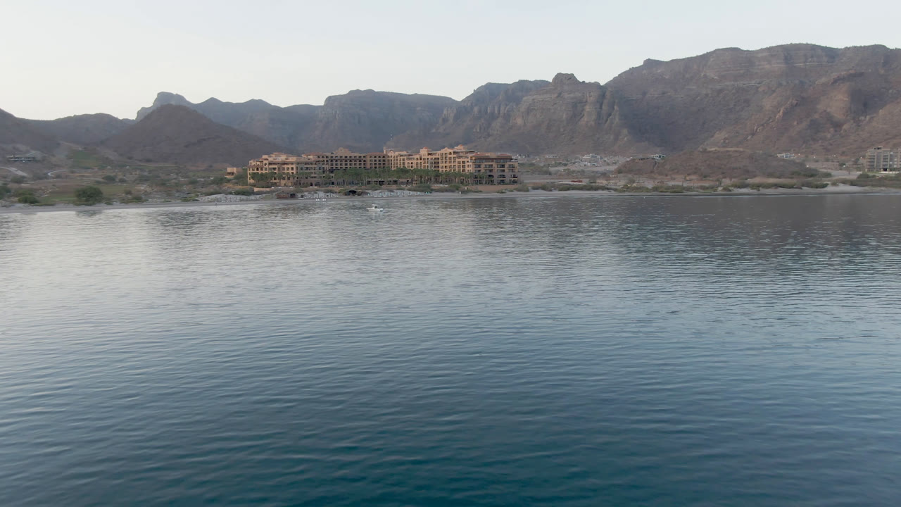 Open bay surface with distant buildings and mountain range.