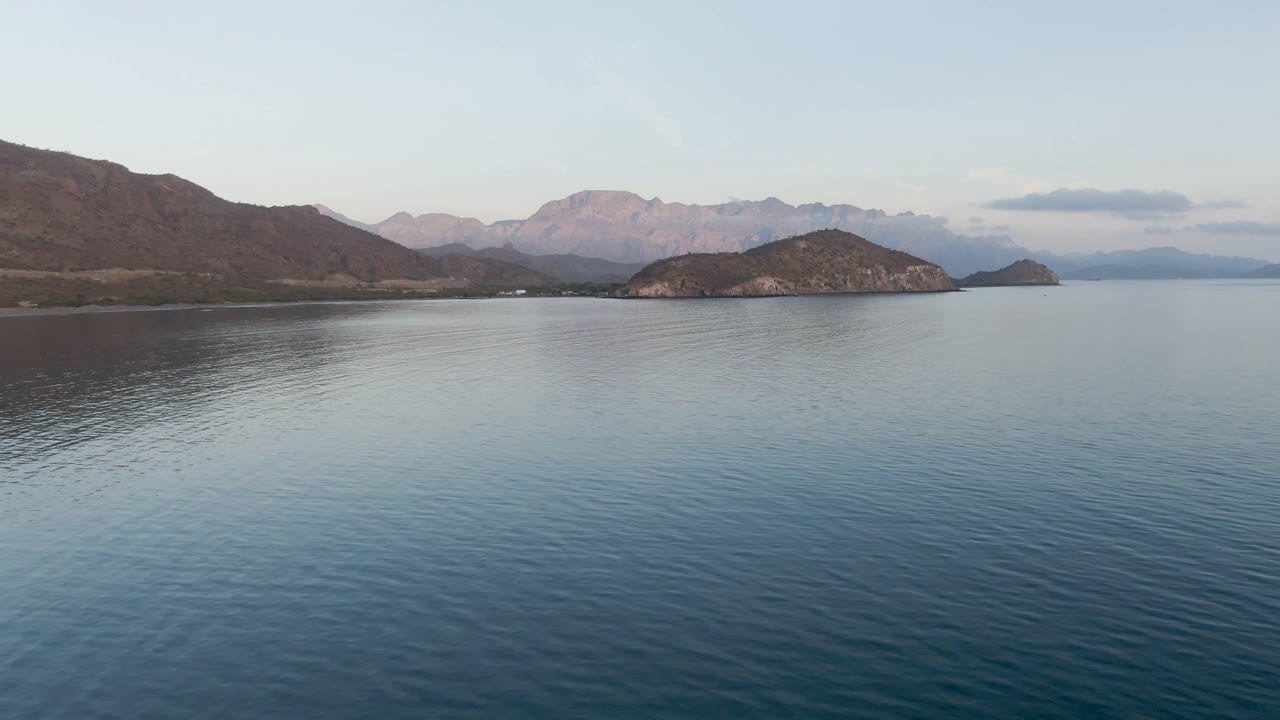 Bay water and mountain shoreline under a pale sky.