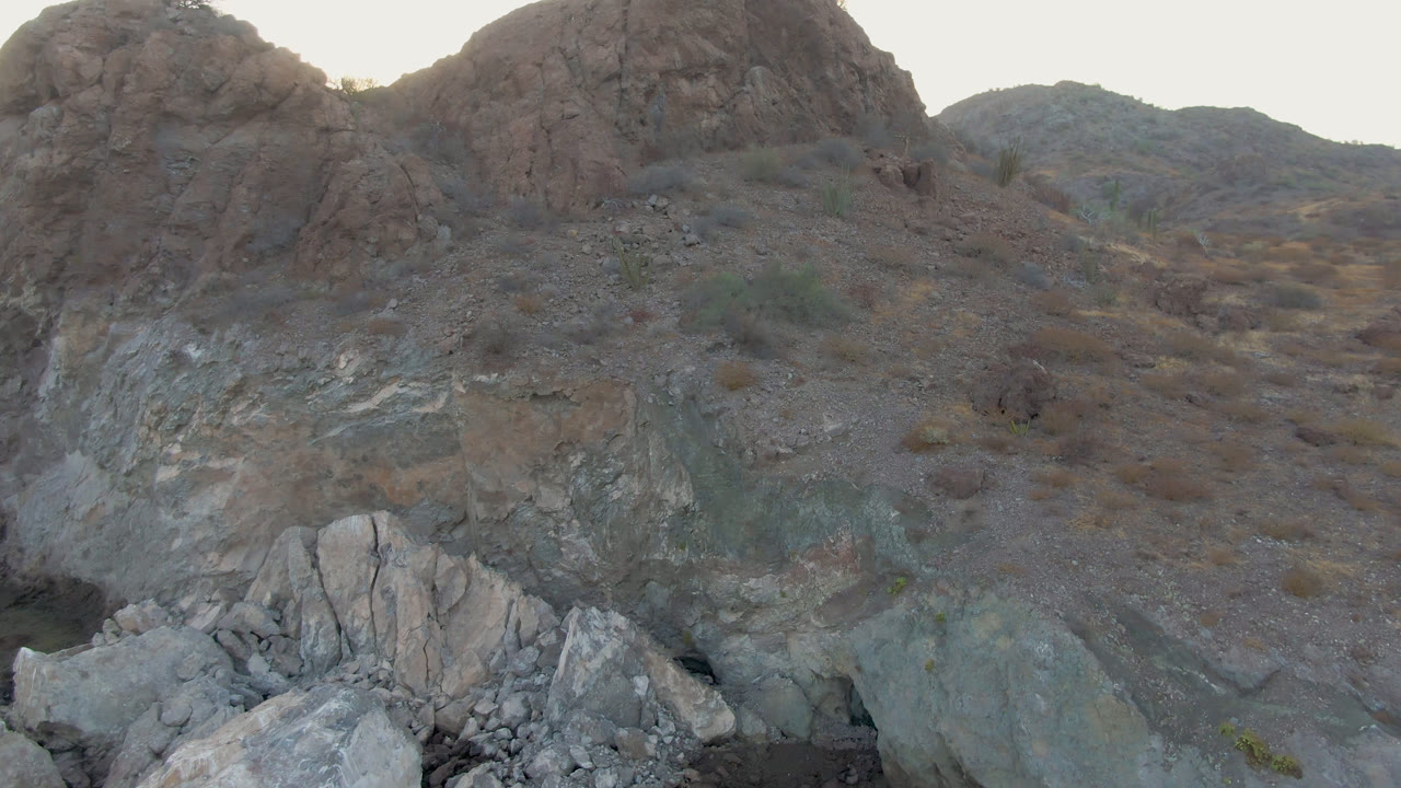 Rocky hillside at Danzante Bay Loreto with pale foreground boulders, dry scrub, shadowed ridges, and no visible people.
