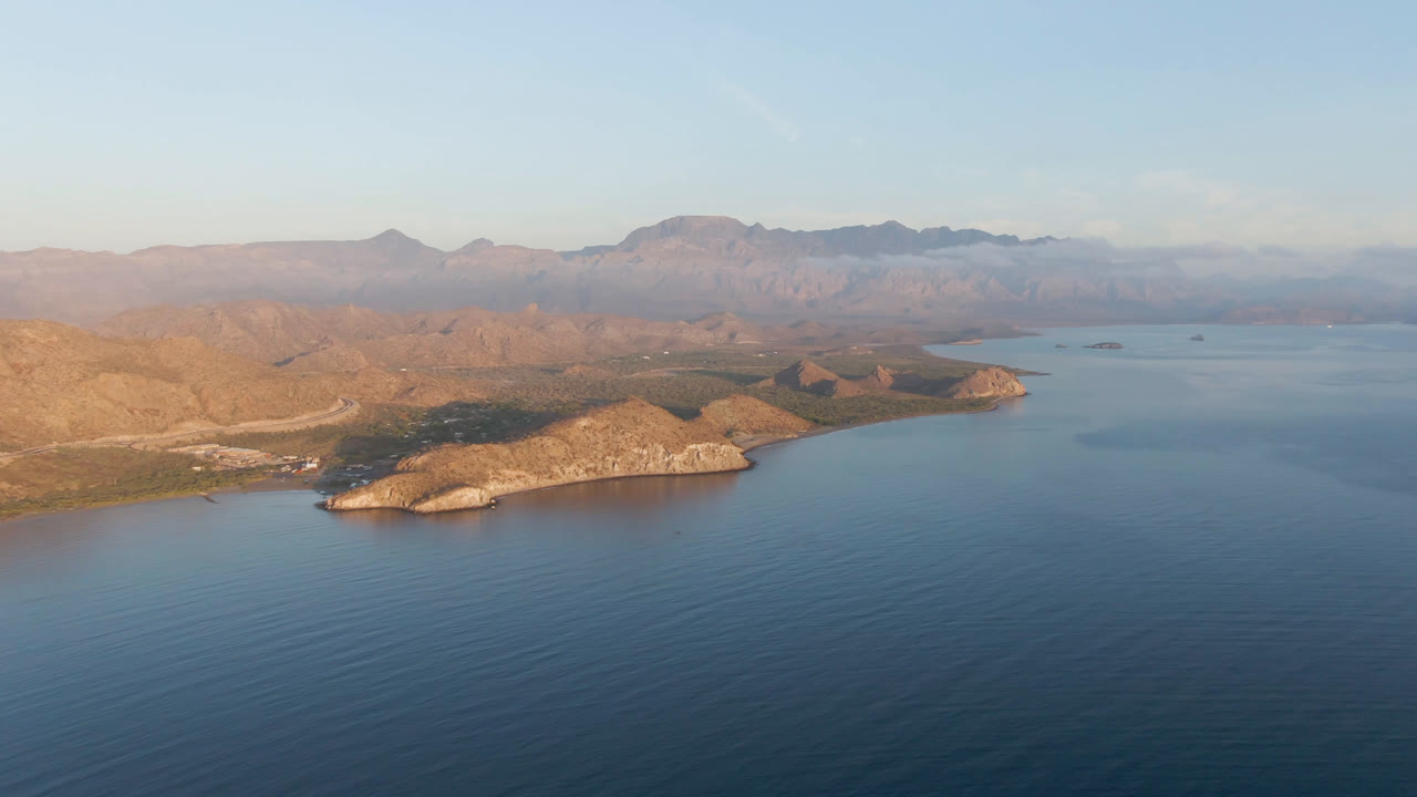 High view across bay water toward rocky landforms and mountains