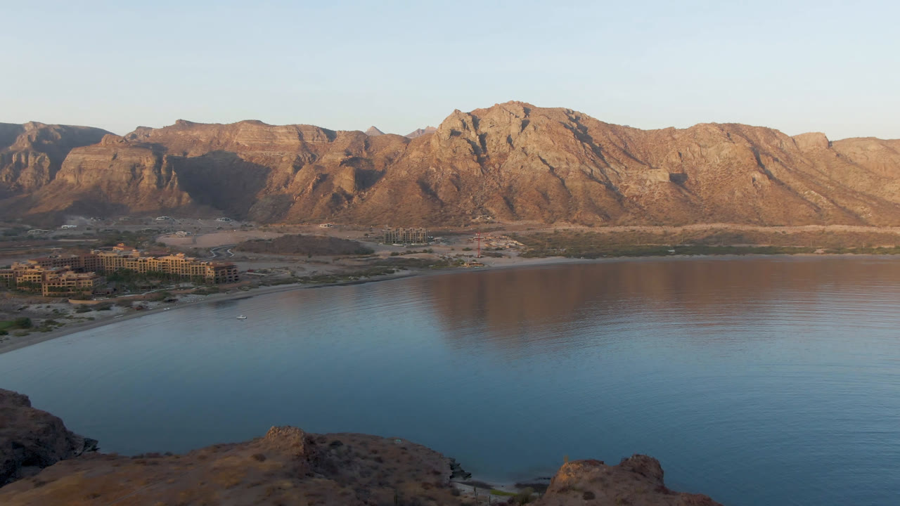 Wide bay water with mountains and shoreline buildings.
