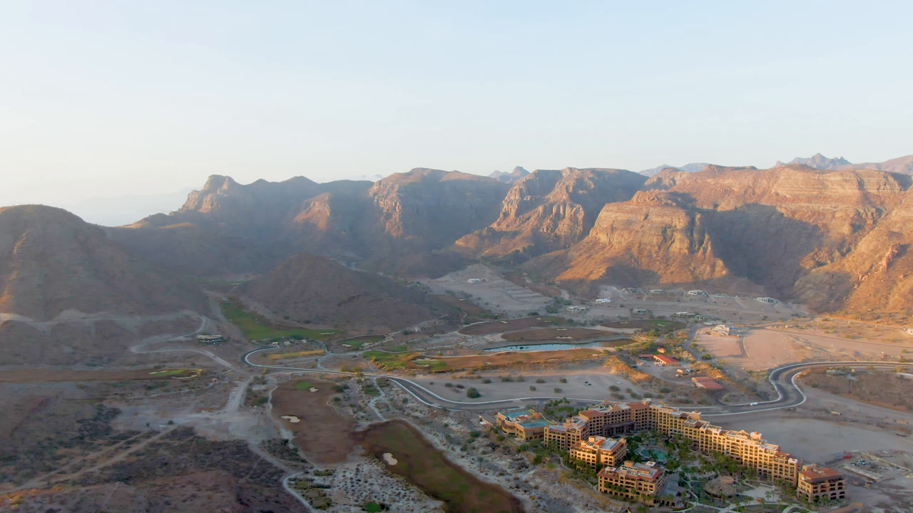 Aerial view of arid mountains, roads, water, and buildings