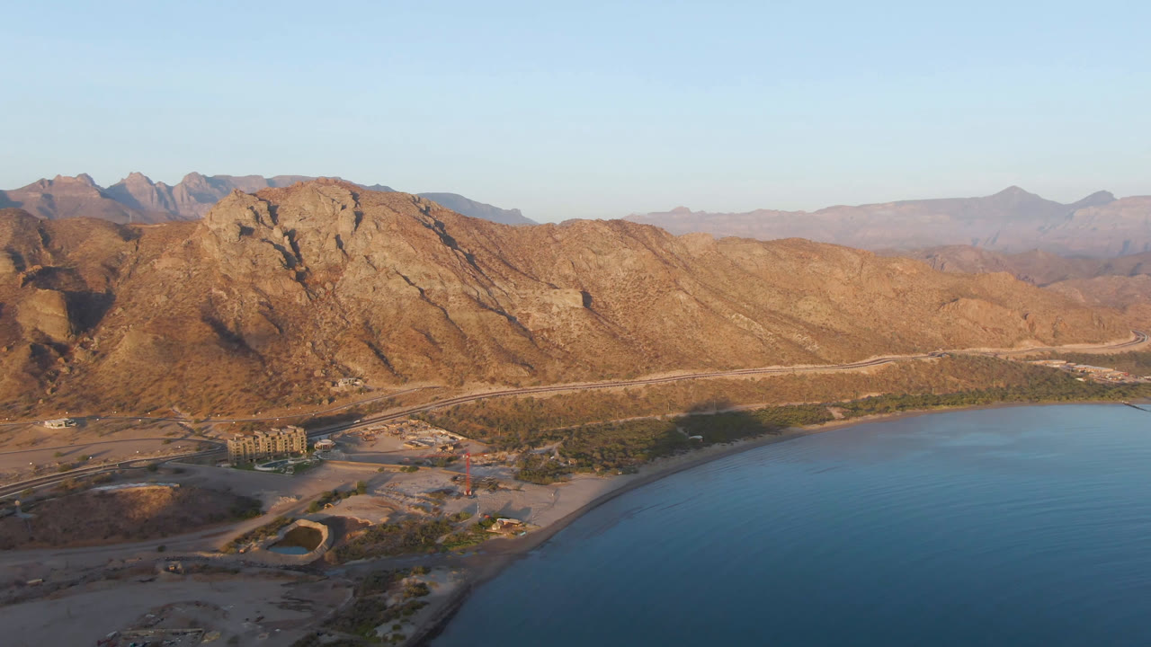 High aerial of Danzante Bay coastline with mountains and road below.
