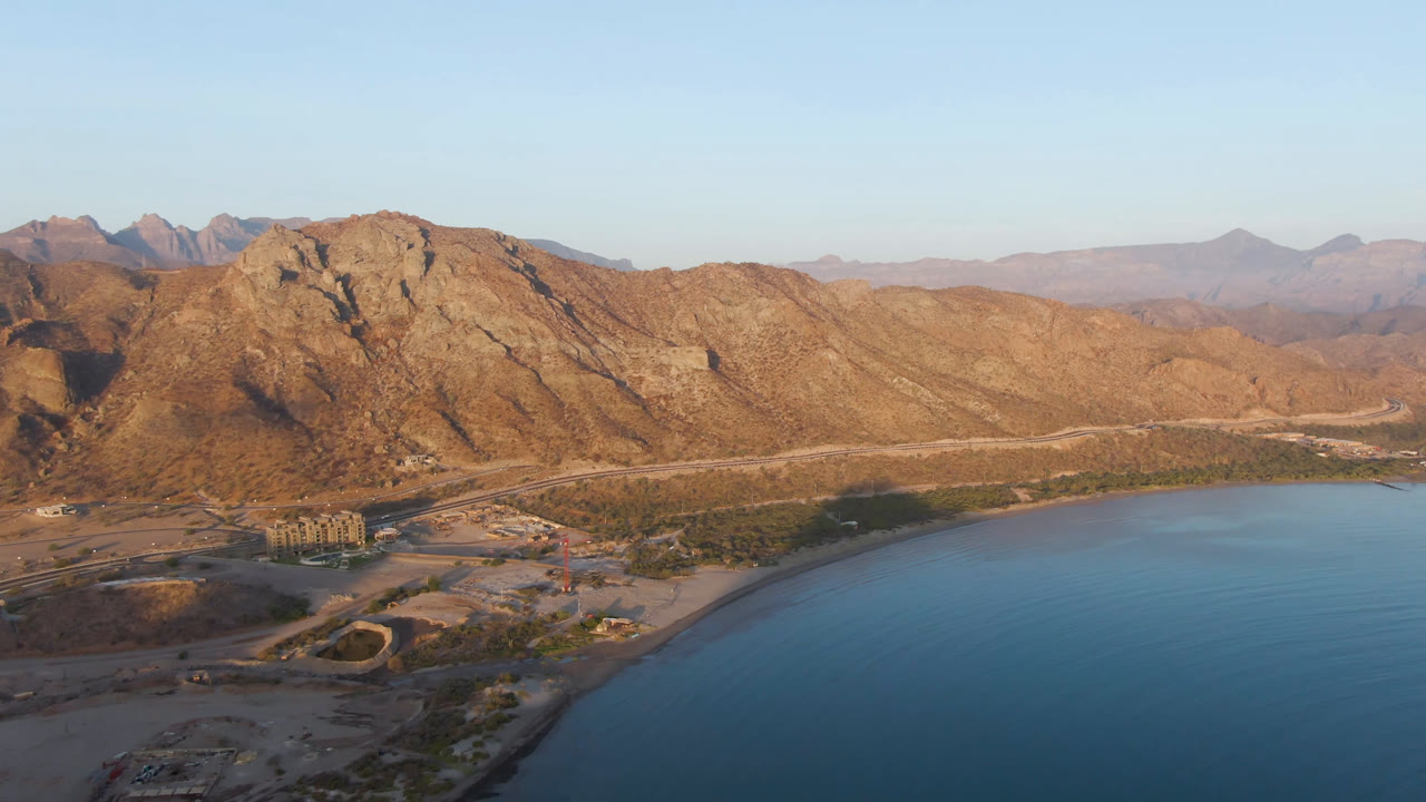 Mountain range and calm bay seen from above.