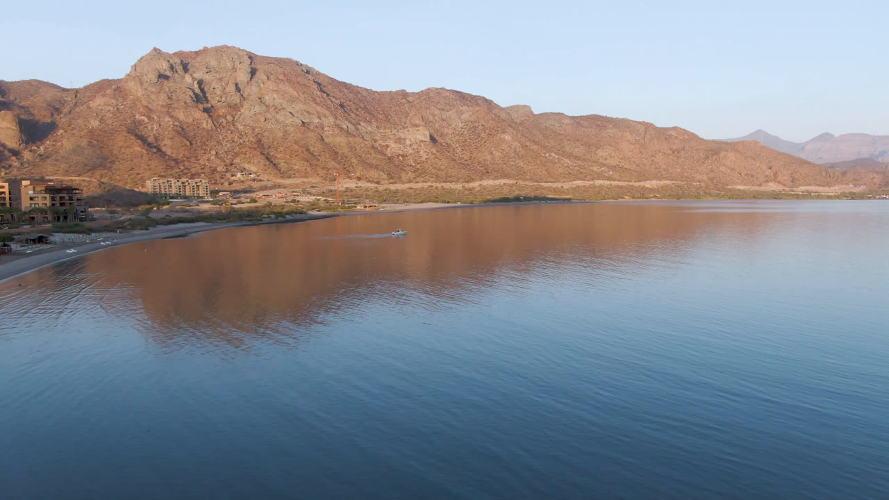 Drone view of Danzante Bay with mountains and a small boat near shore