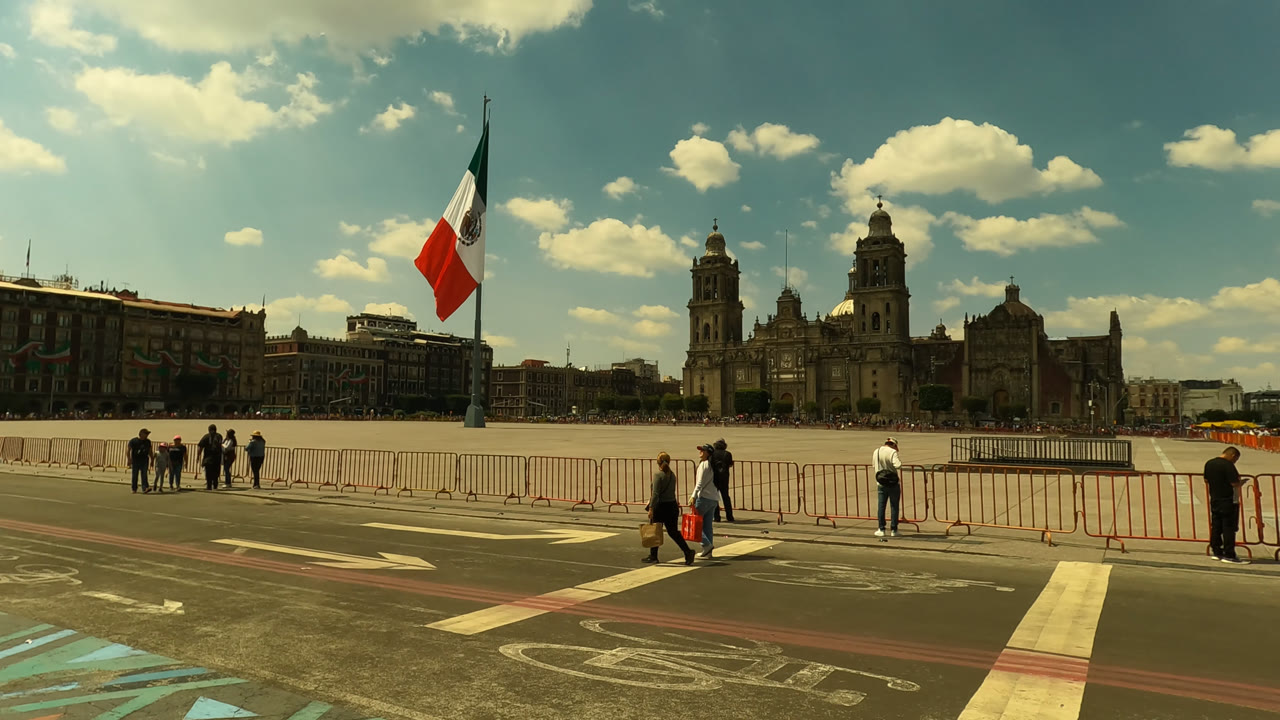 Second frame shows Zocalo Square in Mexico City with the Mexican flag closer to center left, small groups standing behind barriers, and the cathedral facade across the plaza.
