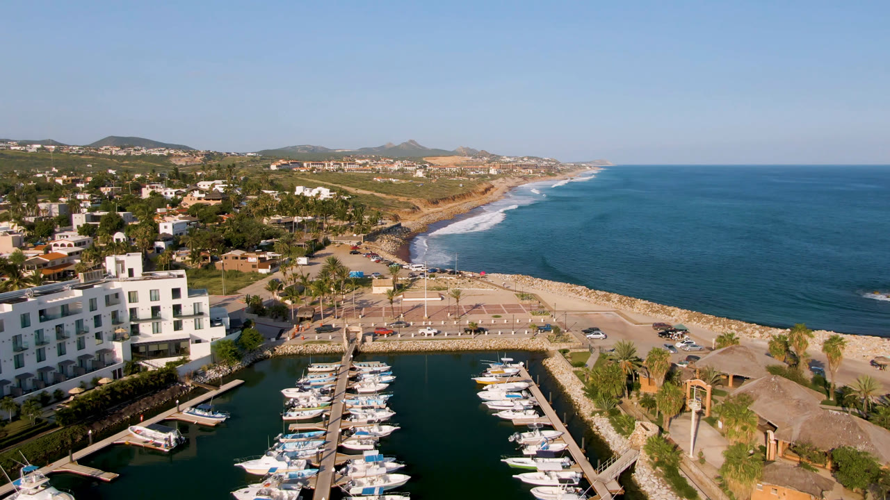 Aerial view of marina boats beside a beach and blue ocean