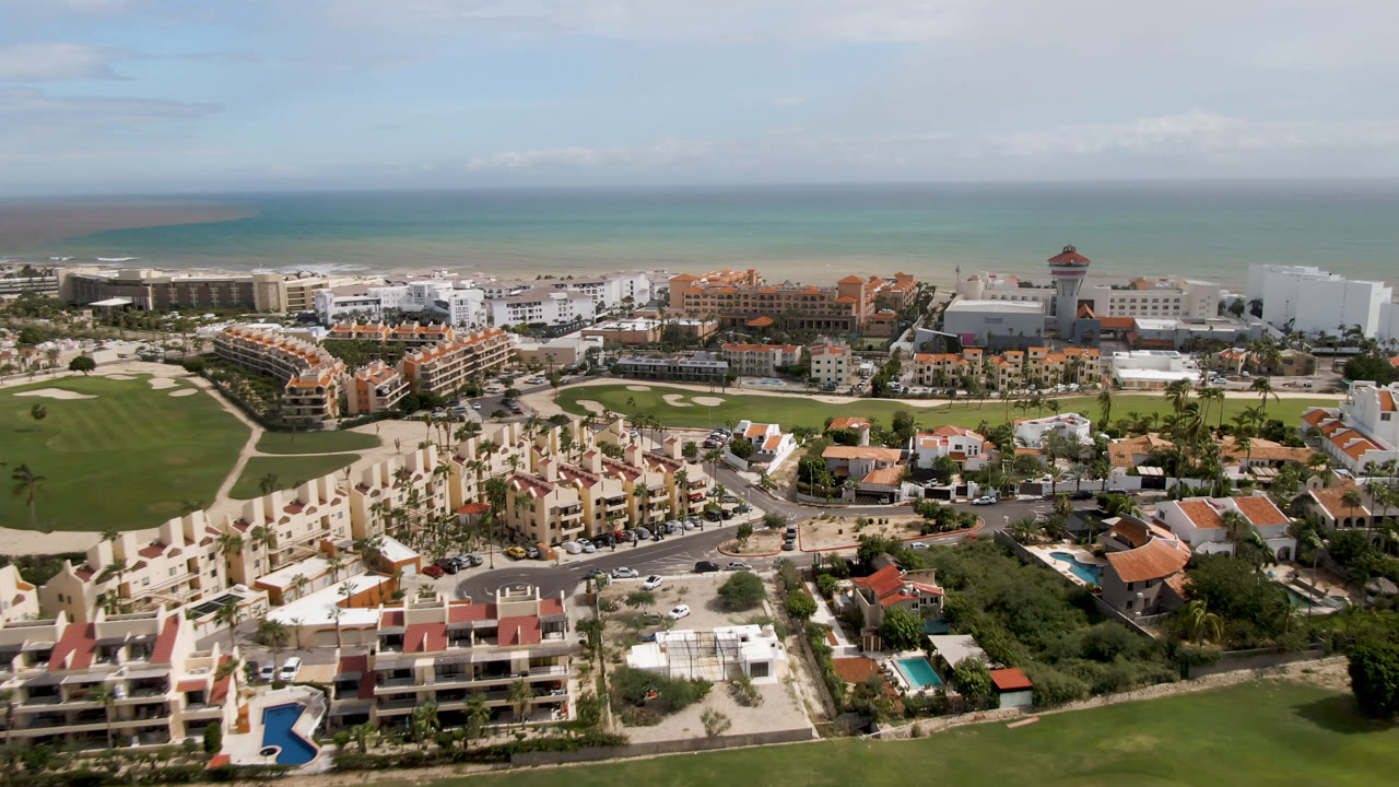 Aerial view of coastal resorts, golf greens, roads, and ocean