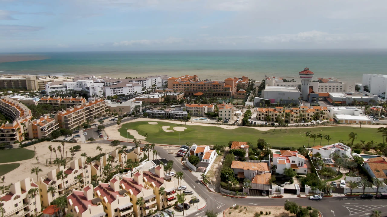 One second into the clip, the San Jose del Cabo aerial view centers more on the golf course and beachfront hotel blocks, with no visible people.