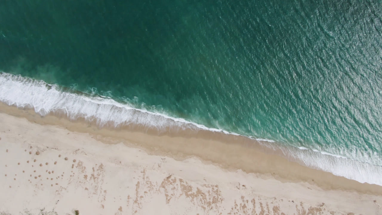 Foam band curling across an empty beach