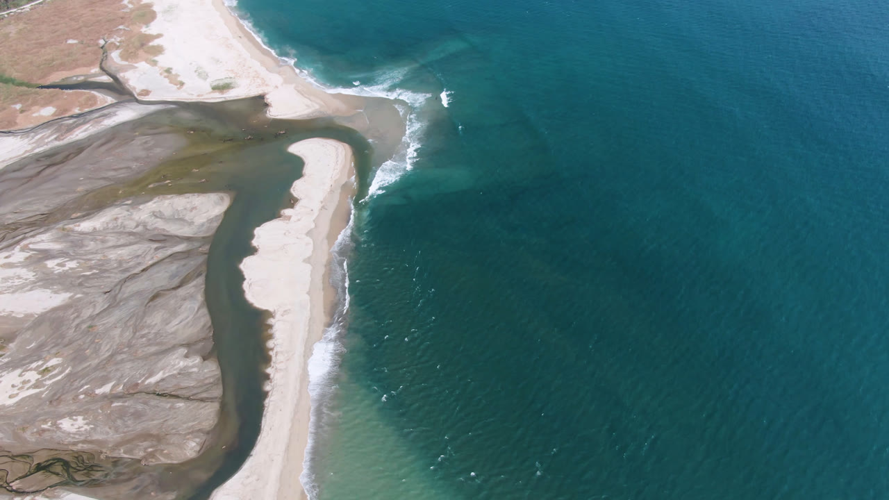 Sand bank and ocean seen from above with shallow water tones