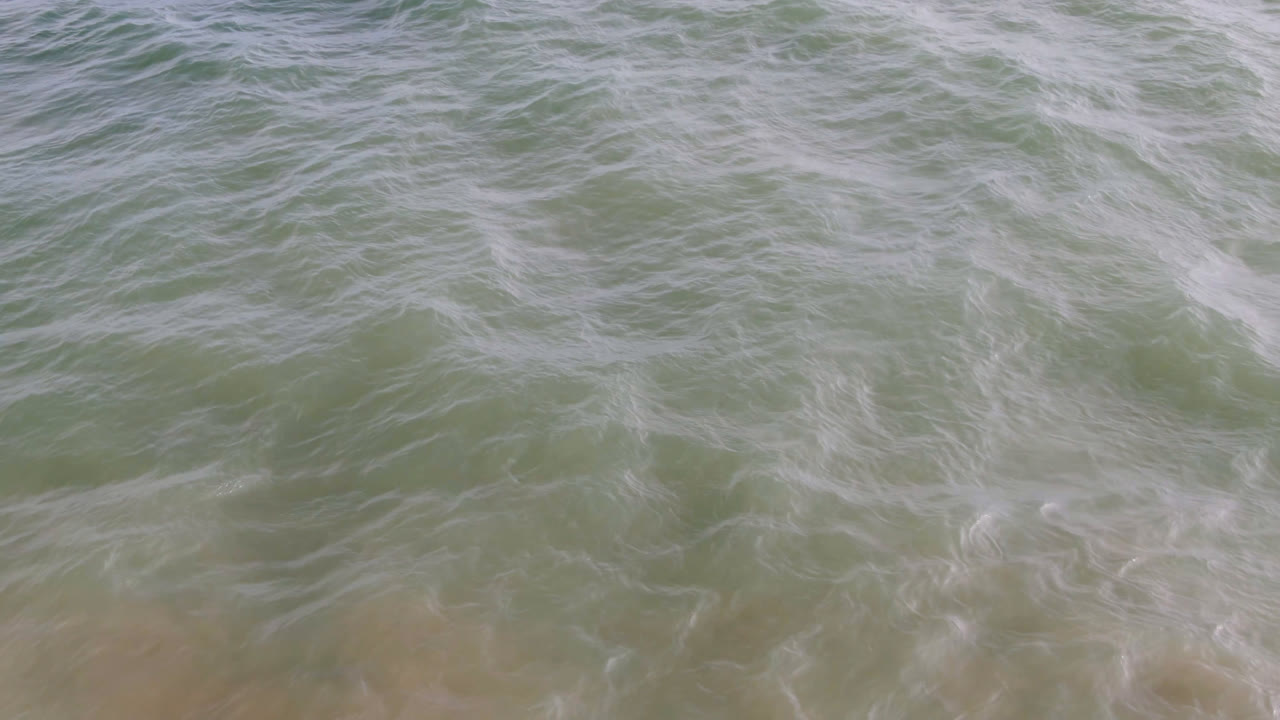 Overhead surf water with a tiny distant surfer near the top edge.