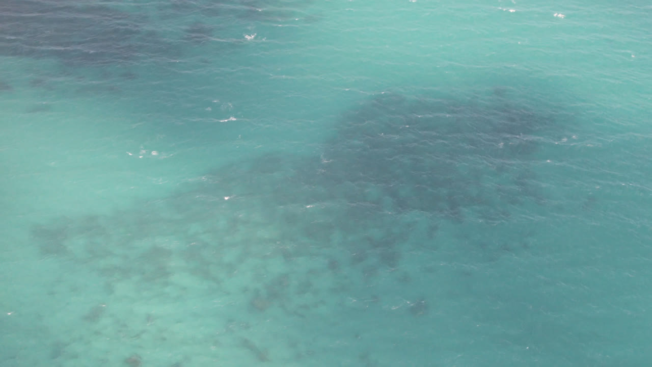 Turquoise ocean surface with darker underwater patches