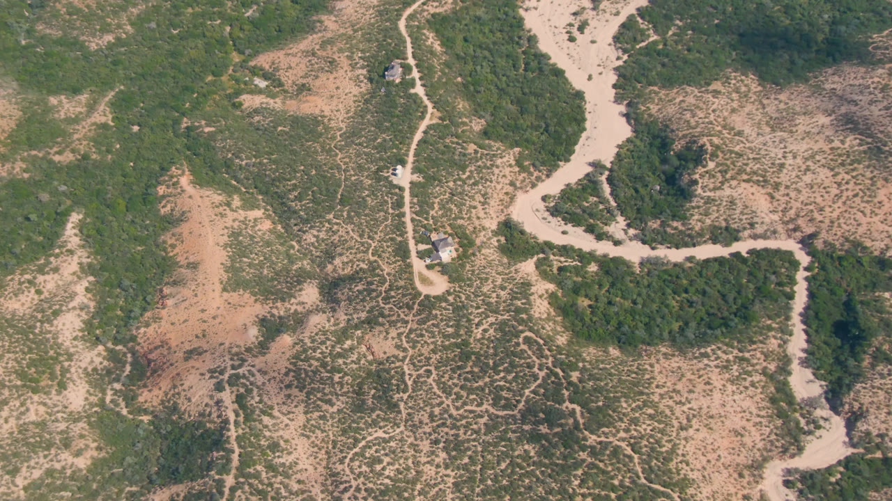 Aerial view of pale dirt roads crossing dry scrubland