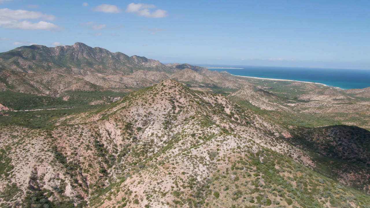 Mountain ridge and coastal plain seen from above with ocean beyond