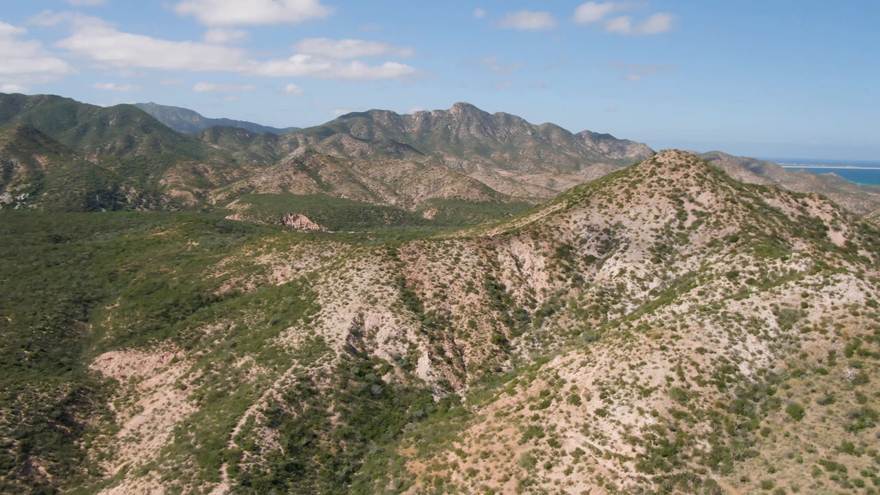 Desert mountain ridge with water visible at the right edge.