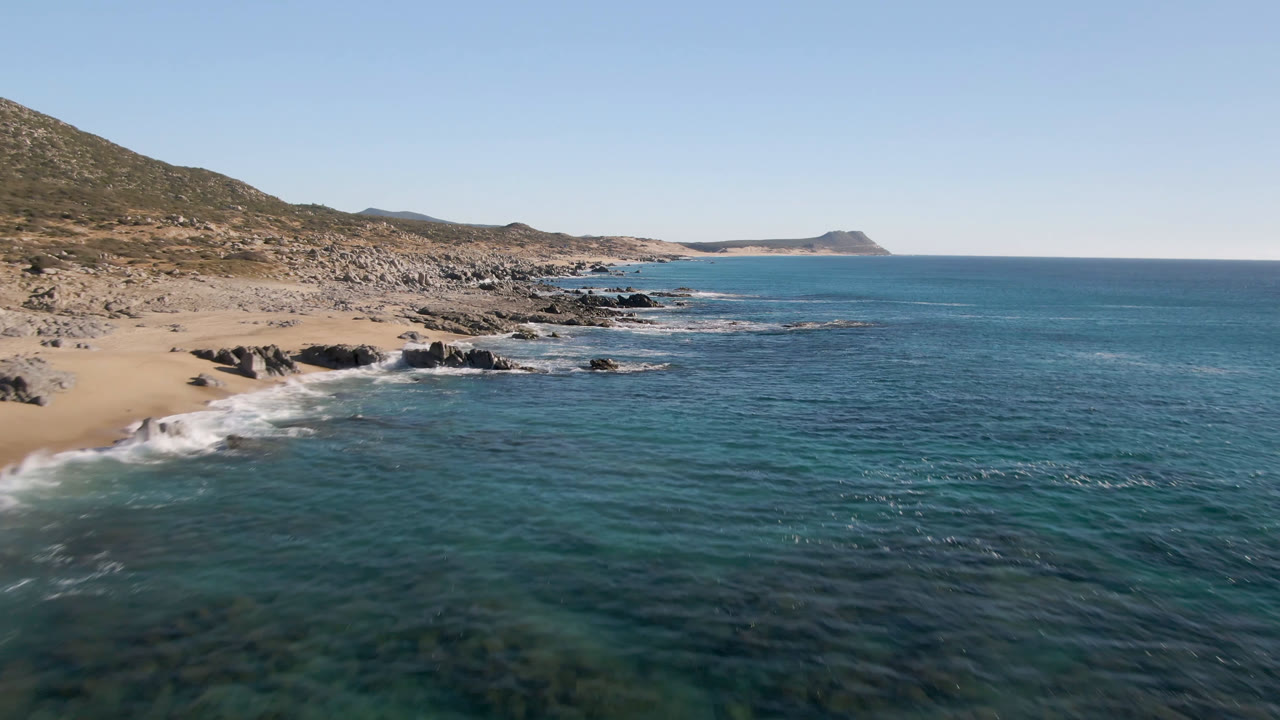 Blue ocean and rugged coastline under a clear sky