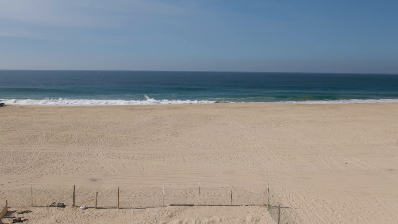 Wide empty sand beach with ocean and horizon