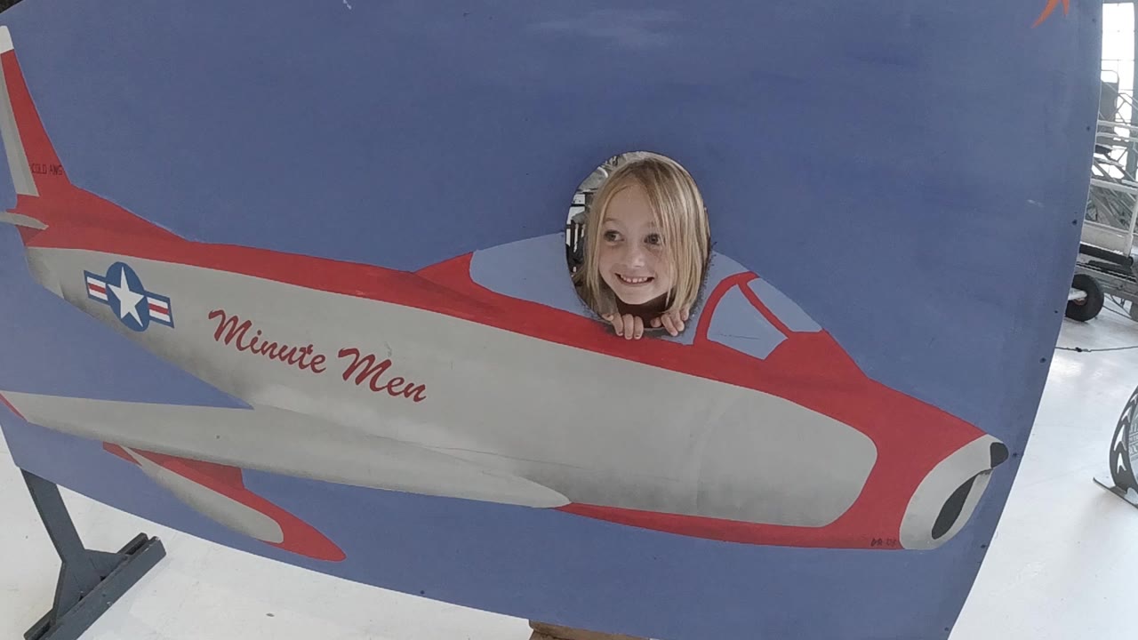 Smiling woman framed in the airplane cockpit hole.