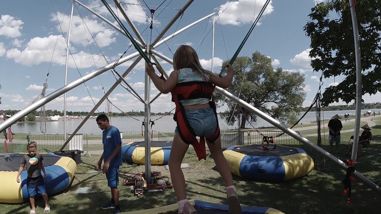 Jumper begins to rise in front of the metal bungee tower.