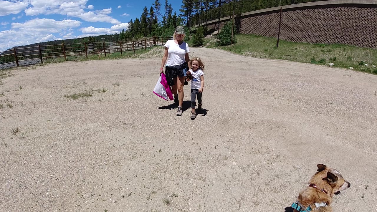 Woman and child walking closer on open dirt road