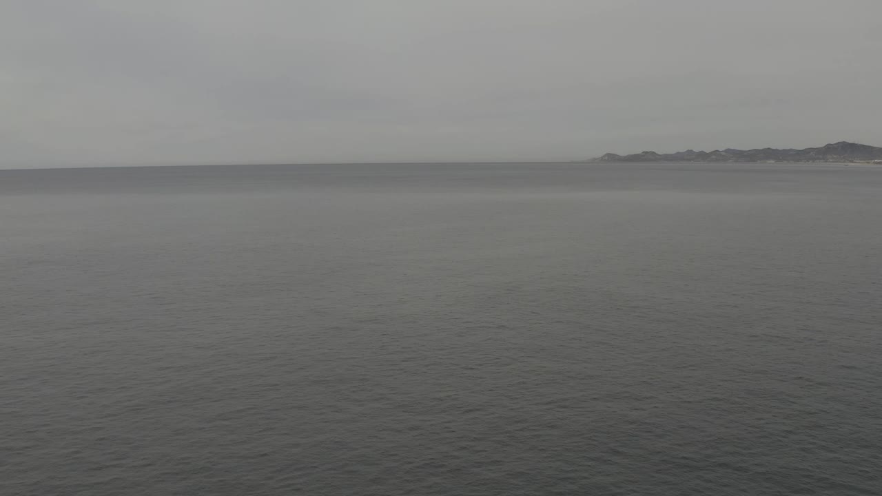 The second frame keeps the horizon high in the composition, with muted ocean texture below and no visible people or vessels.