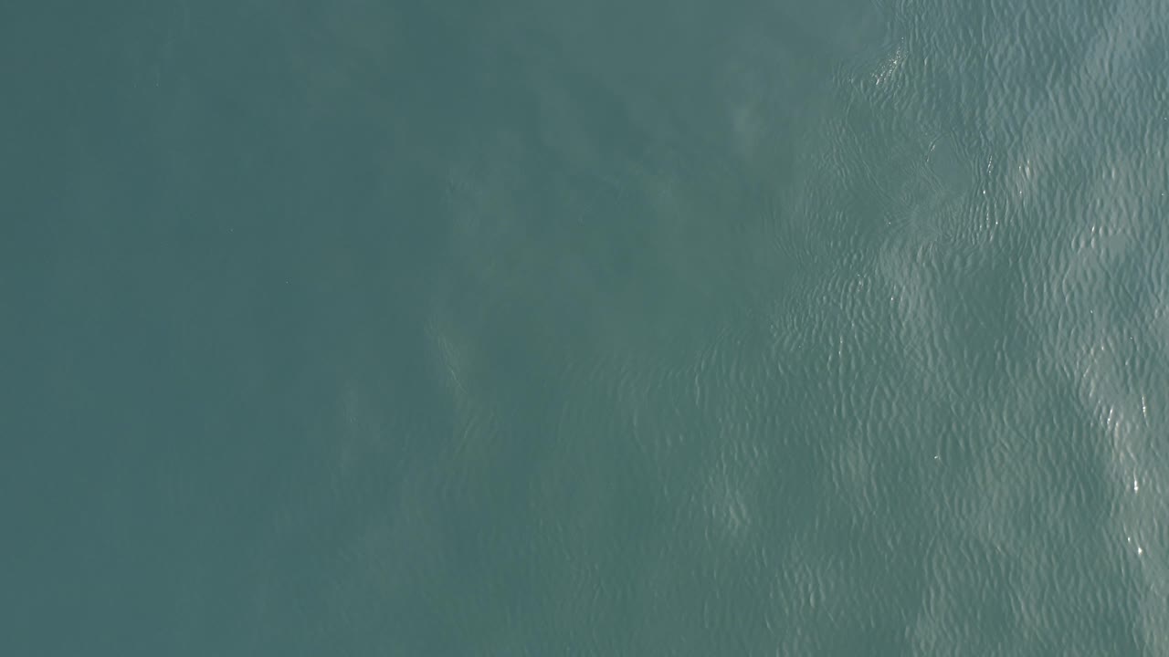 Top-down turquoise ocean surface with faint ripples