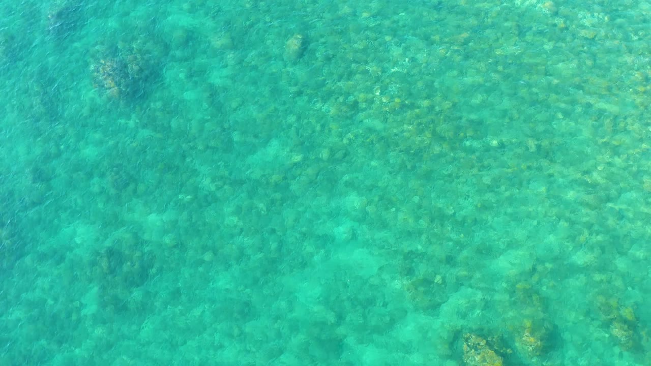 Shallow blue-green water with rocky seabed