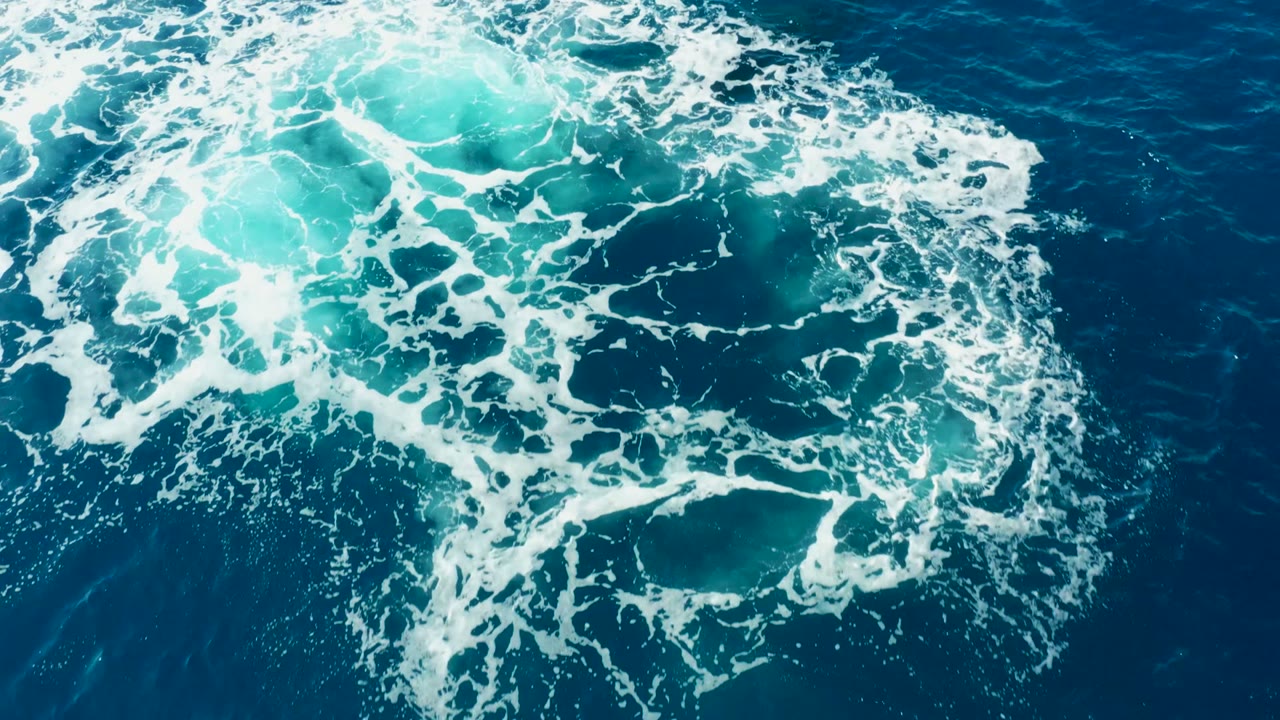 Foam ring over turquoise water after whale dive