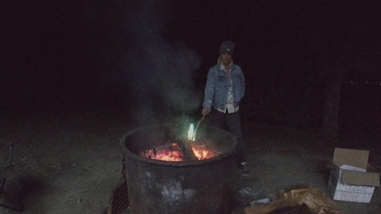 Man tending bright embers in a round fire pit