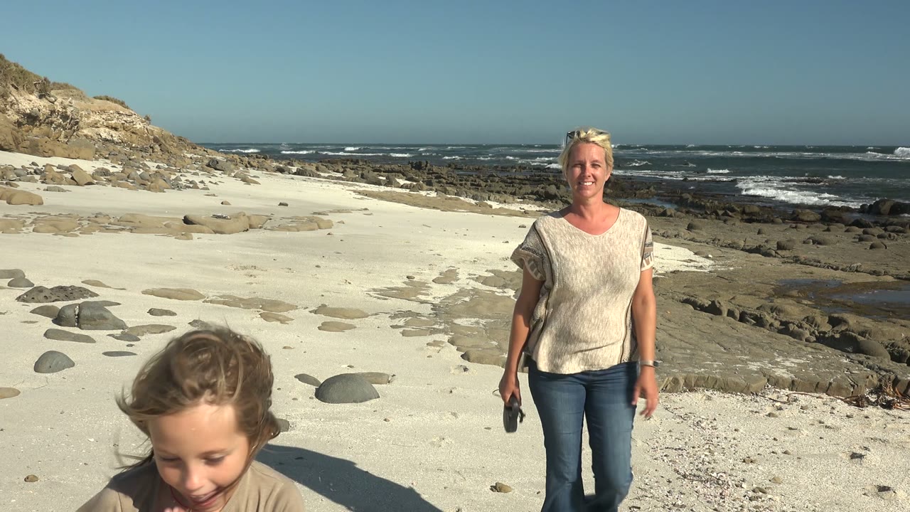 Adult woman walking forward as child exits foreground.