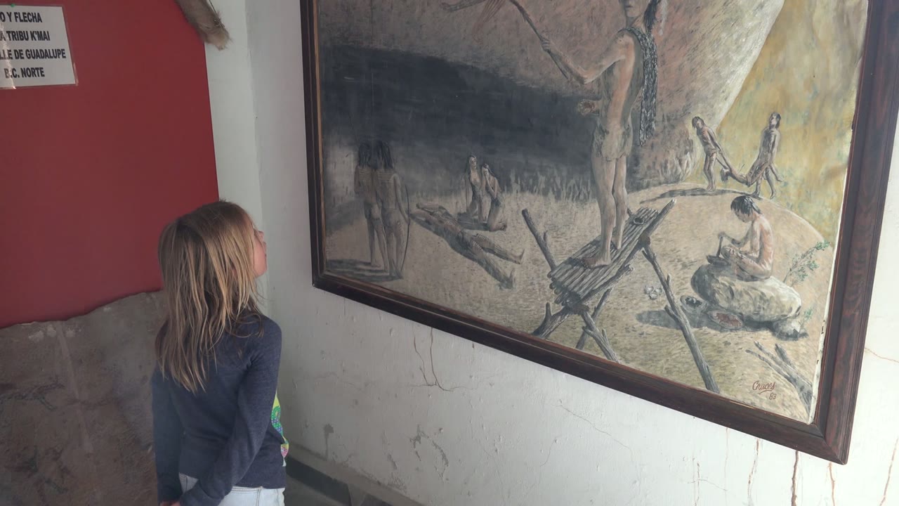 Girl standing close to a framed painting after the pointing hand leaves.