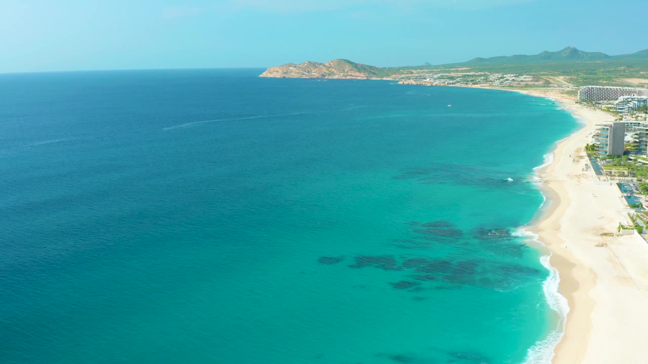 High-angle ocean and beach view with headland across the bay