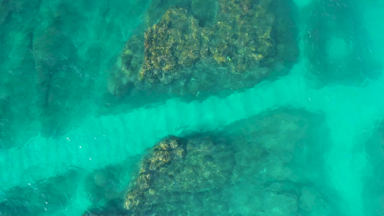 Clear blue-green water crossing rocky shallows