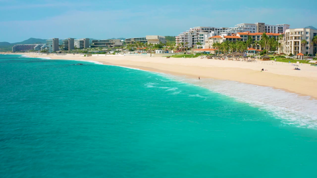 Aerial coastline view with hotels closer to the right side of the beach.